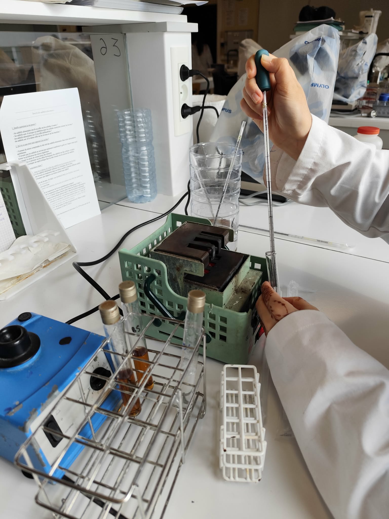 Élève utilisant une pipette pour effectuer des mesures précises lors d’une manipulation en laboratoire de biotechnologies