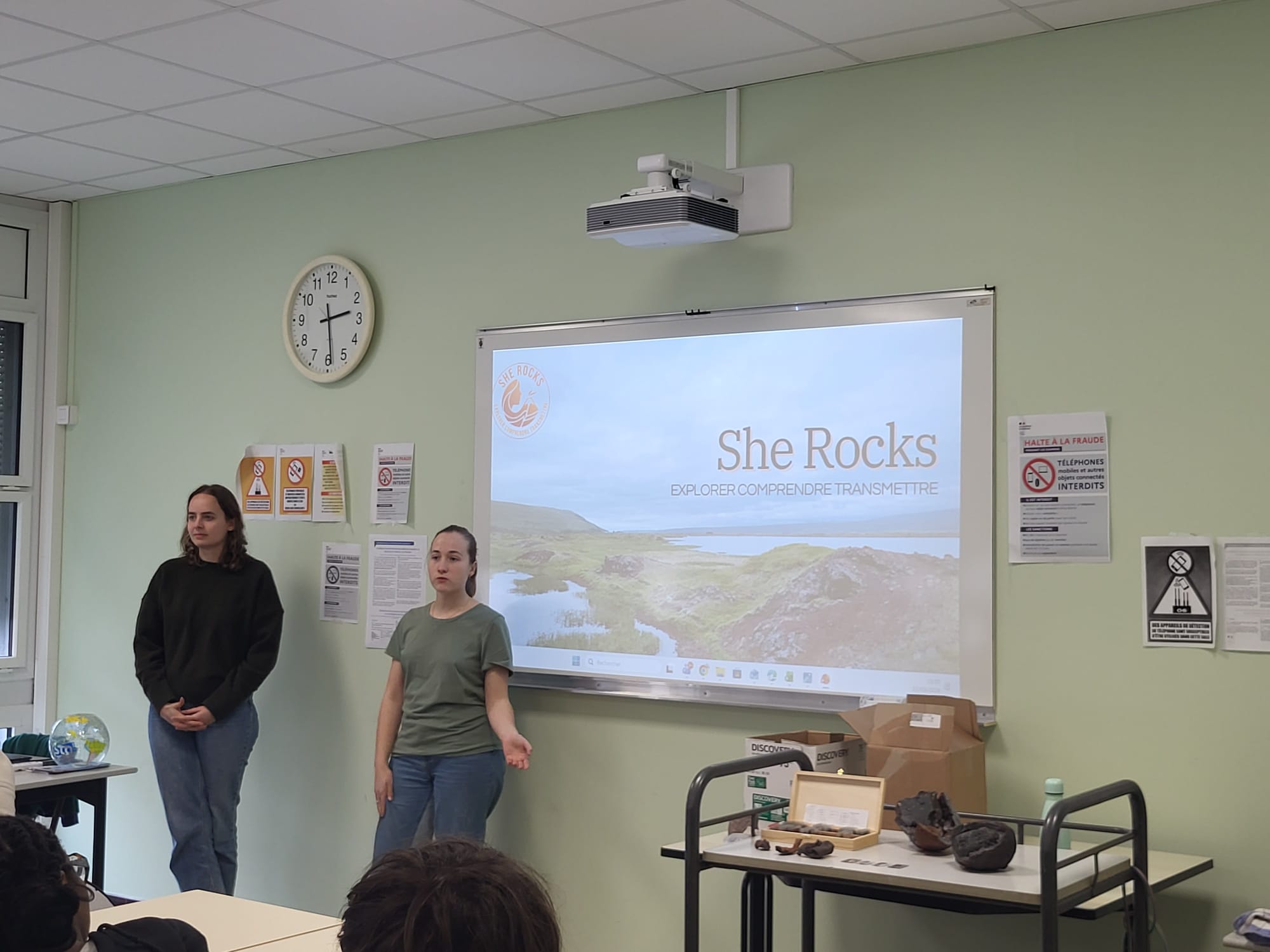Deux étudiantes en ingénierie présentent leur projet scientifique "She Rocks" devant des élèves de Première spécialité SVT, avec une projection expliquant leur étude sur les formations volcaniques islandaises.