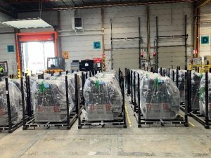 Plusieurs moteurs emballés et entreposés dans un hangar.