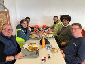 Des élèves et Des professionnels déjeunent ensemble.