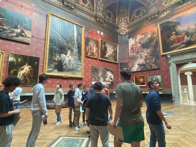 Un groupe d'élève dans une salle remplie de tableau.