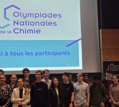 Photo de groupe des participants aux Olympiades Nationales de la Chimie devant l’écran de présentation lors de la cérémonie de clôture.