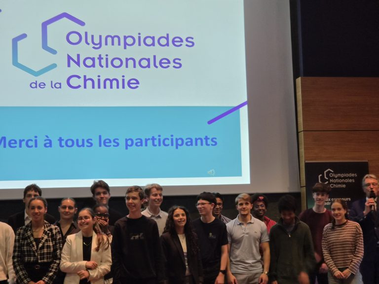 Photo de groupe des participants aux Olympiades Nationales de la Chimie devant l’écran de présentation lors de la cérémonie de clôture.