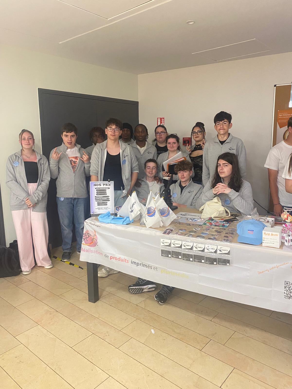 Les élèves de 2MIGC posent devant le stand de leur micro-entreprise « Legacy » lors de la présentation des projets entrepreneuriaux.