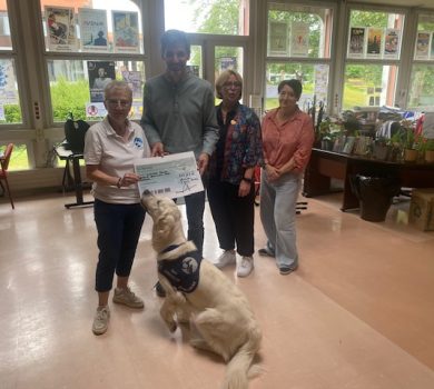 Christine Dupuis, vice-présidente de l'association Handi'Chiens, reçoit un chèque de 547 € remis par les représentants de la cité scolaire Delambre-Montaigne, accompagnée de Snow, chien d'assistance de l'association.