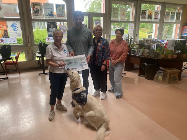 Christine Dupuis, vice-présidente de l'association Handi'Chiens, reçoit un chèque de 547 € remis par les représentants de la cité scolaire Delambre-Montaigne, accompagnée de Snow, chien d'assistance de l'association.