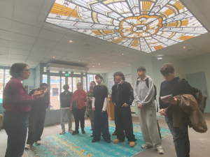 Des élèves de 1RPIP découvrent la Comédie de Picardie accompagnés de leurs enseignantes et de membres de l’équipe du théâtre, sous une verrière art déco.