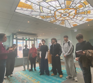 Des élèves de 1RPIP découvrent la Comédie de Picardie accompagnés de leurs enseignantes et de membres de l’équipe du théâtre, sous une verrière art déco.