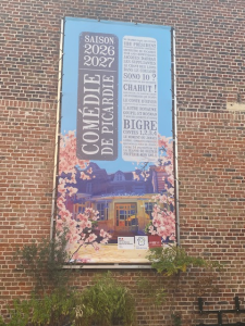 Affiche de la saison 2026-2027 de la Comédie de Picardie installée sur la façade du bâtiment.