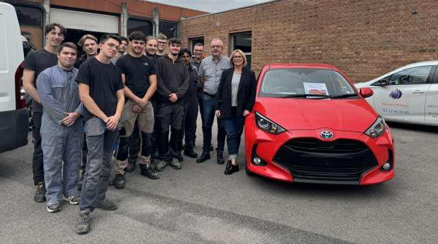 Des étudiants du BTS MVL et des membres du lycée Delambre d’Amiens réunis autour d’une Toyota Yaris Hybride rouge remise à l’établissement par Toyota Motor Manufacturing France.